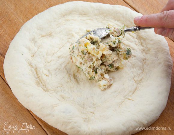 Готовое тесто разминаем в небольшую лепешку, в центре делаем углубление, выкладываем начинку, защипываем края, полностью закрывая ее.