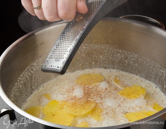 Поместить картофель в кастрюлю со сливками и слегка приварить минут 10. Добавить чеснок и мускатный орех, соль, перец и прогреть на среднем огне.