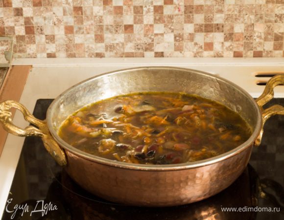 Добавить фасоль. Влить мясной бульон, посолить и довести до кипения. Переложить в кастрюлю с толстым дном, убавить огонь и протушить около часа.
Отдельно обжарить четыре листика бекона до хрустящей корочки.