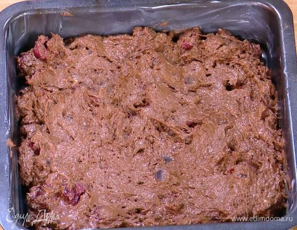 Квадратную форму для выпечки смазать оставшимся сливочным маслом, выложить тесто и разровнять его.