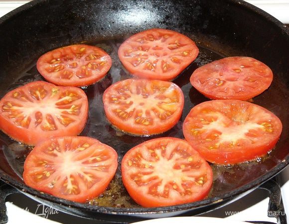Помидоры вымойте и нарежьте толстыми кружочками. Быстро обжарьте на масле на другой сковороде с двух сторон, немного присаливая. 