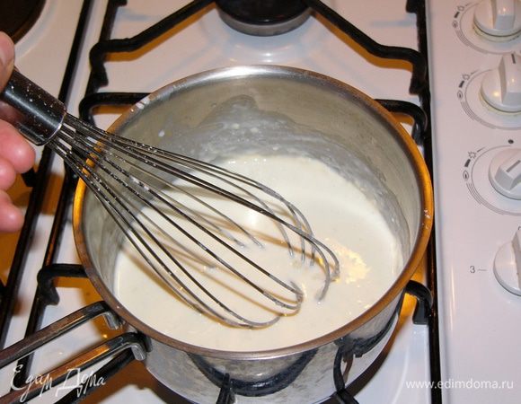 Постепенно вливайте в кастрюлю молоко, непрерывно помешивая венчиком. 