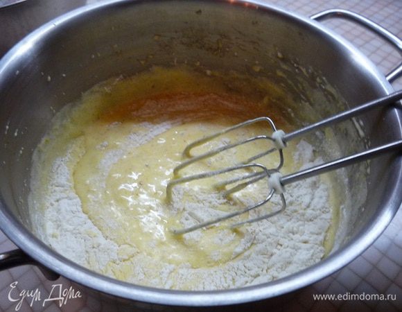 Добавляем растопленное сливочное масло, измельченный фундук и муку, продолжая взбивать на маленькой скорости.