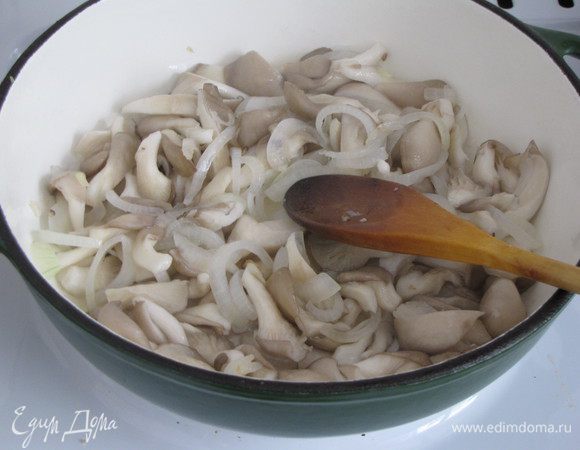 К луку добавить вешенки, убавить огонь и жарить еще 8 минут, помешивая. В конце жарки добавить пропущенный через пресс зубчик чеснока.