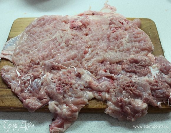 Удалить кончики крыльев. Курицу разрезать вдоль хребта, аккуратно удалить косточки вместе с хребтом. Полностью распластайте тушку. Разрежьте грудки вдоль и разверните, как книжки, чтобы равномерно заполнить те места, где мяса меньше. Накройте тушку слоем пищевой пленки и отбейте молотком, чтобы выровнять поверхность. Затем посыпьте курицу солью и перцем.