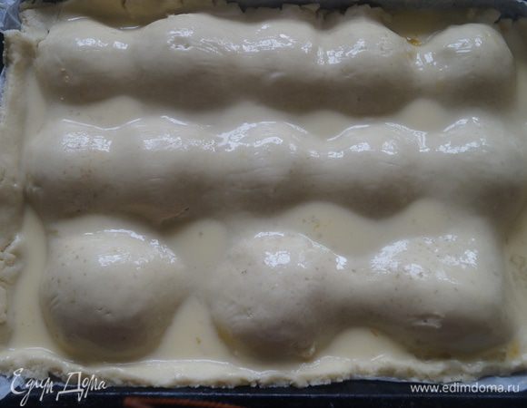 Оставшуюся часть теста раскатать в пласт толщиной 3-4 мм и выложить поверх яблок, защипать края. Верх смазать взбитым яйцом со сливками.