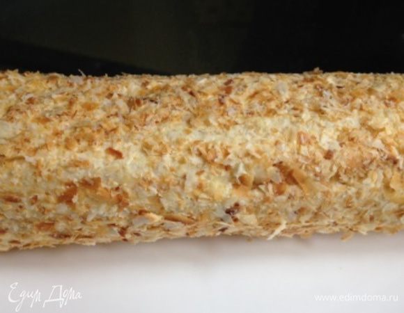 При помощи пищевой пленки придать торту форму полена.
Завернуть в пленку и убрать в холодильник на некоторое время.
Развернуть и присыпать крошкой из отложенных заранее полосок.