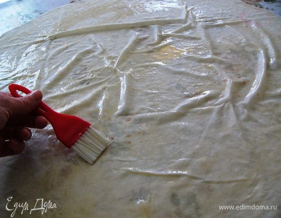 Сливочное масло растопить и смешать с оливковым. На столе разложить первый слой теста фило и с помощью кисточки смазать тесто маслом.