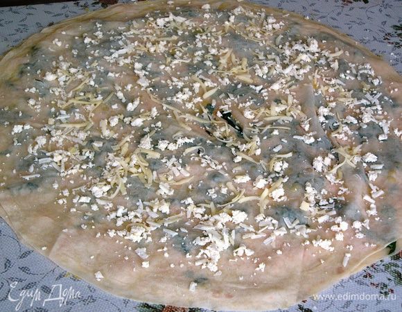 Поверх шпината кладем третий слой теста, смазываем маслом, равномерно посыпаем сыром и брынзой.