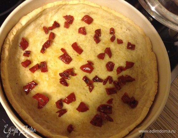 Тесто делаю как всегда более подробно можно посмотреть в любом из моих рецептов: складываю в блендер муку, масло, соль, сахар и пробиваю в крошку, добавляю яйца и воду пробиваю что бы в ком собралось, сразу раскатываю и выкладываю в форму, наколоть вилкой отправить в морозилку на 15 минут. Достать и выпекать при 180С 15-20 минуту с грузом. Убрать груз выкладываем начинку: сначала помидоры, порезанные на кусочки, в ингредиентах указано 10 долек, можно больше как Вам нравится.