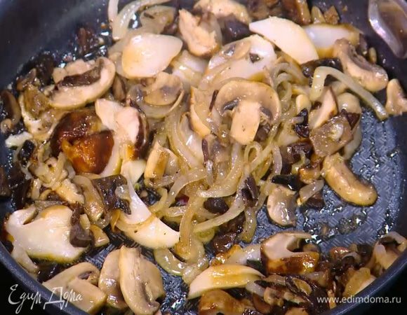 Размороженные белые грибы нарезать пластинками, добавить в сковороду, все перемешать.