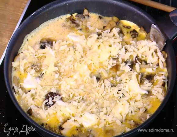 На яйца чайной ложкой выложить небольшие кусочки сливочного сыра и посыпать все натертым твердым сыром.