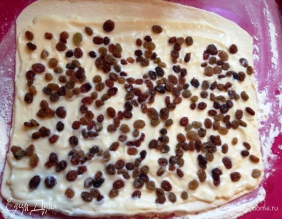 Тесто раскатать, смазать заварным кремом, посыпать изюмом.