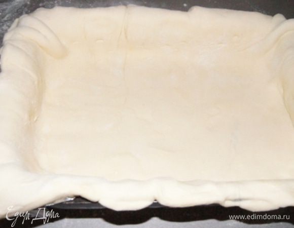  Разделить тесто на 2 неравные части. Раскатать большую часть. Форму выстелить фольгой и смазать растительным маслом, положить пласт теста, так чтоб края свисали. У меня форма 27х17 см, можно выпекать и в круглой.