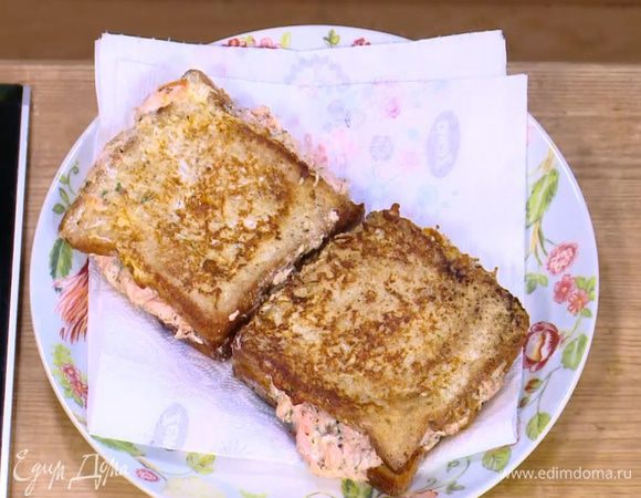 Сэндвичи окунуть в молочно-яичную смесь, так чтобы весь хлеб полностью пропитался, выложить на сковороду и обжарить с обеих сторон до золотистой корочки, затем переложить на бумажное полотенце, чтобы удалить излишки жира.