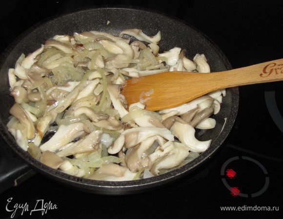 На сковороде разогреть оставшееся масло и обжарить нарезанный тонкими полукольцами лук в течении 2 минут. К луку добавить нарезанные вешенки. Убавить огонь, жарить, помешивая, 8 минут. Убрать сковороду с огня.