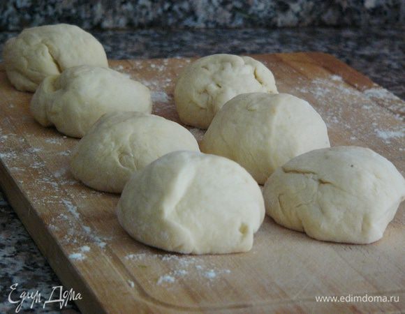 Когда тесто готово, надо его обмять, выложить на рабочую поверхность, слегка присыпанную мукой и разделить на равные кусочки, величиной, примерно, с яйцо. Из этого количества теста получается примерно 15 кусочков. Включаем разогреваться духовку на 180°С!