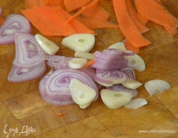 Оставшийся шалот и зубчик чеснока нарезать тонкими кружками наискосок.