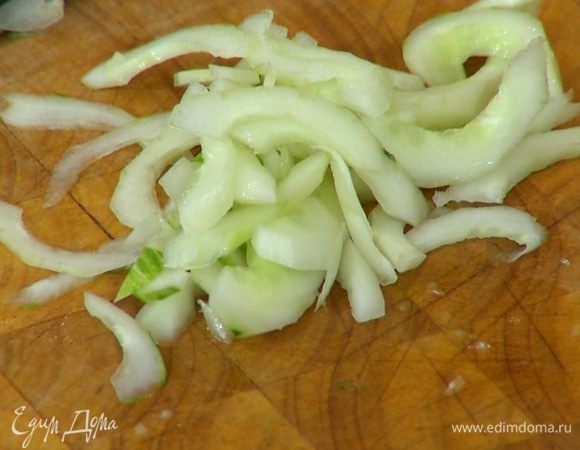 Огурец почистить, разрезать, ложкой удалить семена, мякоть нарезать наискосок тонкими полосками.