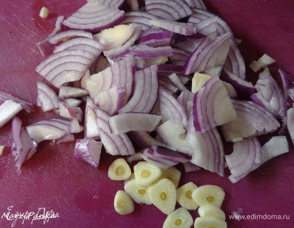 Лук порезать полукольцами, чеснок — пластинками. В эту же сковороду выкладываем лук и чеснок, капнув немного масла.