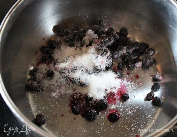 Чернику сложить в ковш, добавить оставшийся сахар и прогреть до растворения сахара.