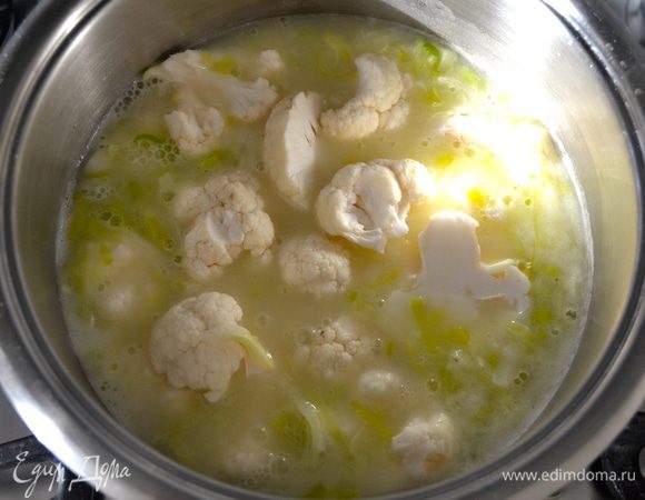 Влейте осторожно в три приема в кастрюлю к "ру" горячий бульон и, интенсивно помешивая, полностью растворите смесь в бульоне (вливаем именно частями, чтобы избежать образования комочков). Доведите до кипения и добавьте цветную капусту. Накройте крышкой и варите 30 минут на небольшом огне.