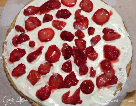 Затем пропитанный корж смазываем сливками и кладем клубнику.