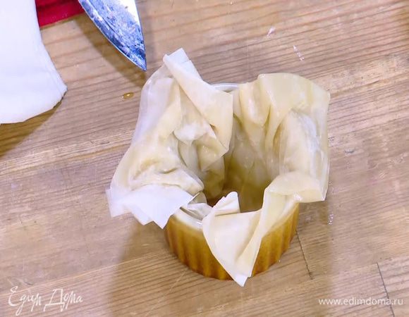 Поместить сложенное тесто фило в небольшие керамические формы так, чтобы края теста слегка свешивались.