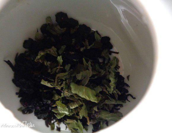 Положить черный чай, сушенные ягоды черной смородины и мяту.