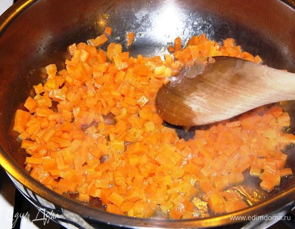 В кастрюле или сковороде с толстым дном растопить сливочное масло. Обжарить морковь 1-2 минуты. Нет необходимости доводить морковь до мягкости и карамельности, достаточно, чтобы она слегка пустила краску. 