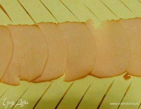 На тесто уложить ломтики ветчины.