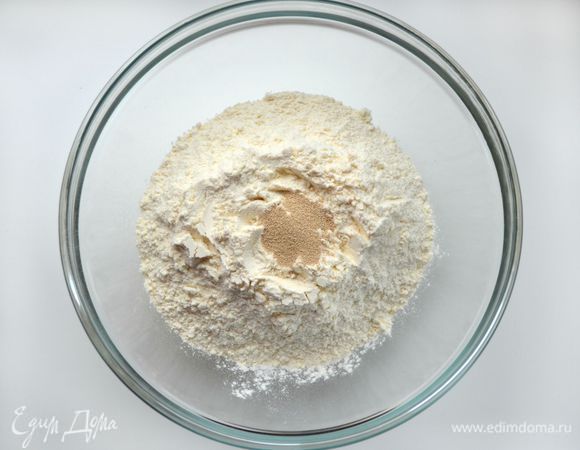 Соединить дрожжи с просеянной мукой и добавить к молочно-яичной массе. Замесить крутое тесто. Накрыть его салфеткой и дать постоять минимум 30 минут.