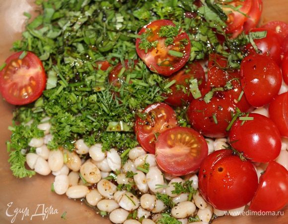 В миску положить фасоль, помидоры и зелень. Добавить заправку и перемешать.