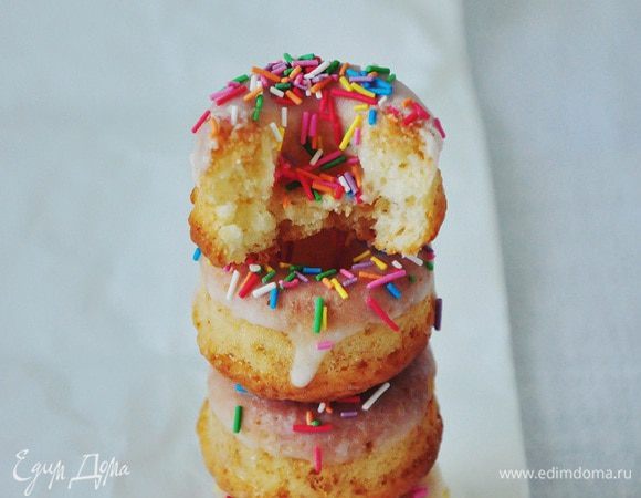 Глазурь. Смешать пудру и молоко до однородной массы, утопить каждый пончик в ней и украсить цветной посыпкой. Вместо сахарной глазури можно использовать растопленный шоколад.