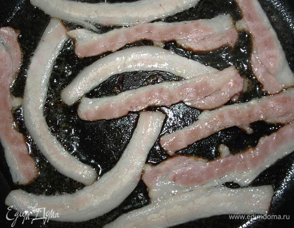 Ломтики бекона режем на две части вдоль. Масло разогреваем в сковороде и обжаривает бекон до золотистой корочки.  Бекон можно заменить грудинкой. 