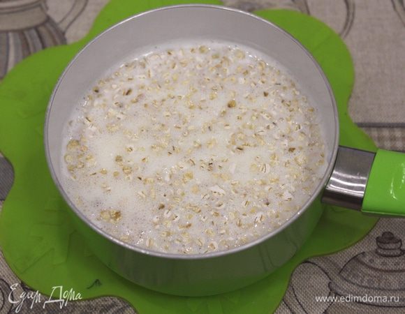 Хлопья залить молоком и поставить на огонь вариться.