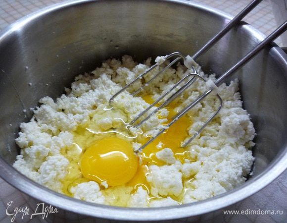 Творог выкладываем в чашку, добавляем яйца и взбиваем до однородности.