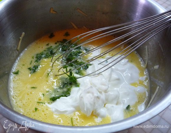 Добавляем к яйцам мелко нарезанную зелень и сметану. Солим и перчим по вкусу. Перемешиваем.