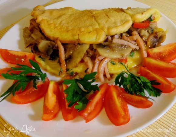 Готовый омлет сложить пополам и выложить на тарелку. Подавать со свежими помидорами.