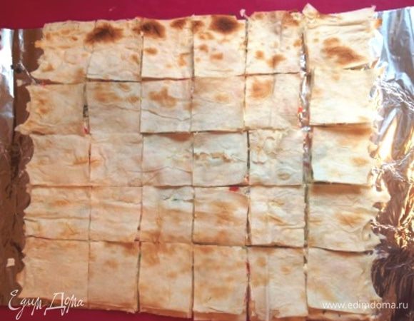 Сверху положить 2-ую часть лаваша, тоже смазать сыром, присыпать зеленью и крабовыми палочками. Также поступить и с 3-им лавашом. Оставшимся 4-им лавашом накрыть и острым ножом разрезать на небольшие кусочки.