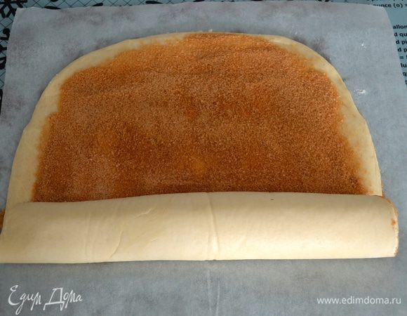 Осторожно свернуть тесто в рулет, помогая себе пекарской бумагой...