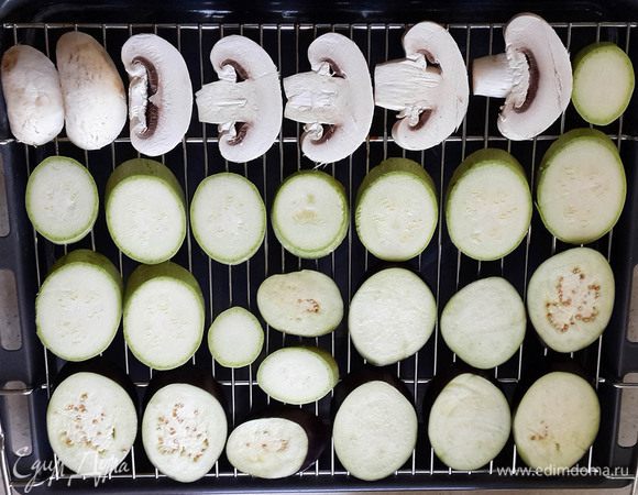 Вымыть все овощи и грибы. Обычно шампиньоны не моют, а только обтирают тряпочкой. Но мне удобнее помыть в воде. Порезать овощи кружочками по косой, а грибы просто пластинками. Баклажаны замочить в сильно подсоленной воде, чтобы не горчили. Грибы и кабачки посолить и поперчить в глубокой посуде, перемешать. Выложить на решетку. Под решетку подставить противень.