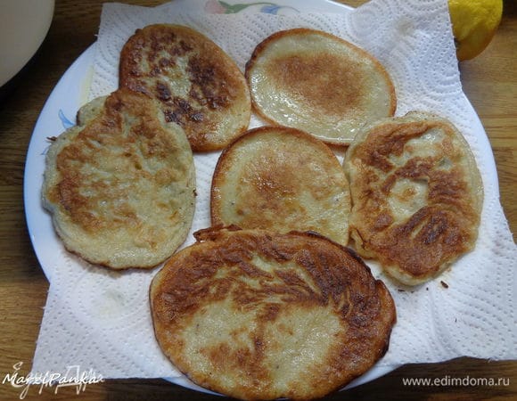 Выкладываем оладьи на блюдо. Я простелила салфетками, потому что первая партия жарилась на масле.