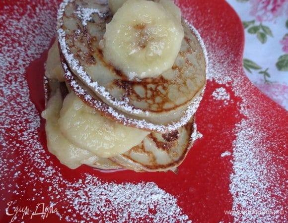 1 банан нарезать шайбочками и сбрызнуть лимонным соком.

На тарелке собрать горку из оладьев, прокладывая их бананами. Щедро посыпать сахарной пудрой.

Приятного аппетита!