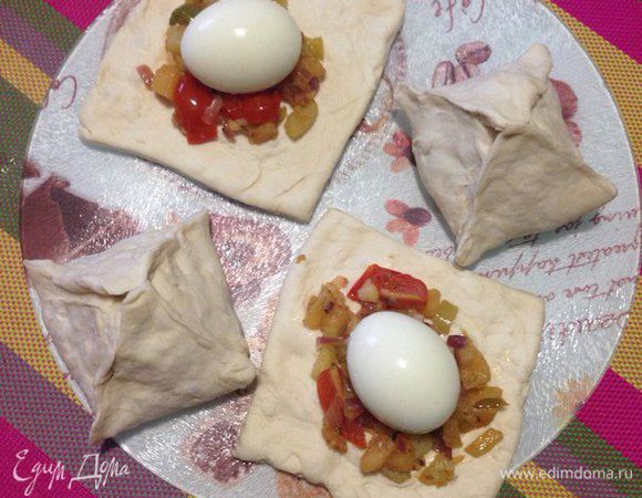 На кусочки теста выложить обжаренные овощи и яйца вкрутую и защепить.