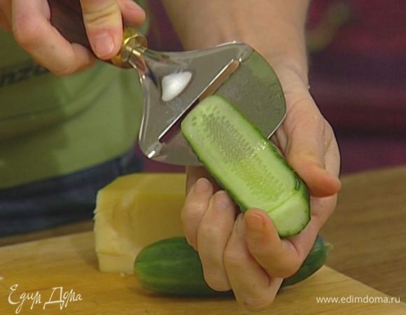 Огурец нарезать вдоль тонкими пластинками.