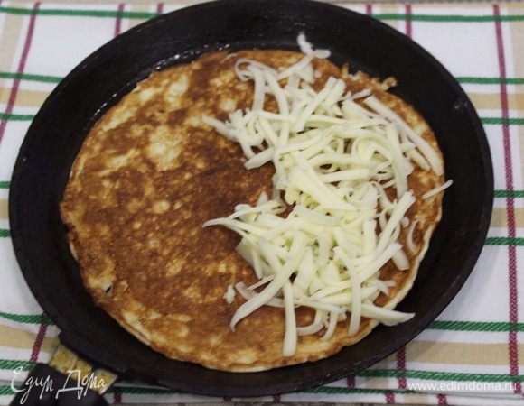 Переворачиваем блин, кладем на него любую начинку (у меня сыр), можно положить помидорки, зелень, колбаску, творог с зеленью и т.д. Закрываем крышкой и оставляем еще на 2-3 минутки.