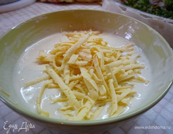 Для сметанной заливки: в миске взбиваем сметану с яйцом, добавляем муку, разрыхлитель, солим и перчим по вкусу. Добавляем натертый на крупной терке сыр. Перемешиваем.