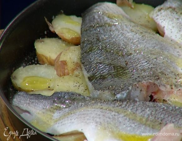 В форму для запекания влить пару ложек оливкового масла, выложить кружки картофеля, сверху поместить рыбу кожей вверх, сбрызнуть все оставшимся оливковым маслом, посолить и поперчить.