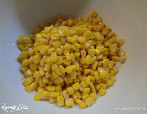 Слить лишнюю жидкость от консервированной кукурузы и положить в салатник.